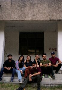 A group of friends smiling while sitting on outdoor steps, capturing a casual and joyful moment.